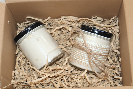 Two Aurora Vita Co. skincare jars in branded boxes, resting on shredded eco-friendly packing paper. Premium, all-natural whipped shea butter.